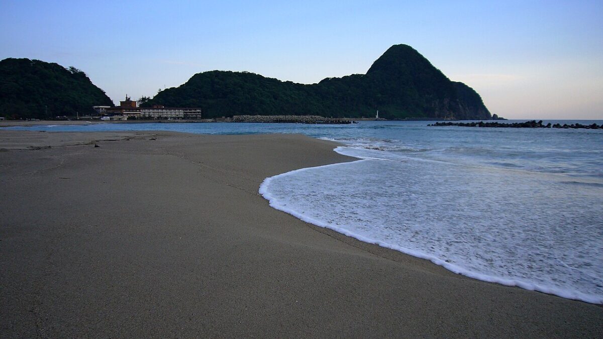 弓なりに続く竹野浜の白い砂浜と猫崎半島