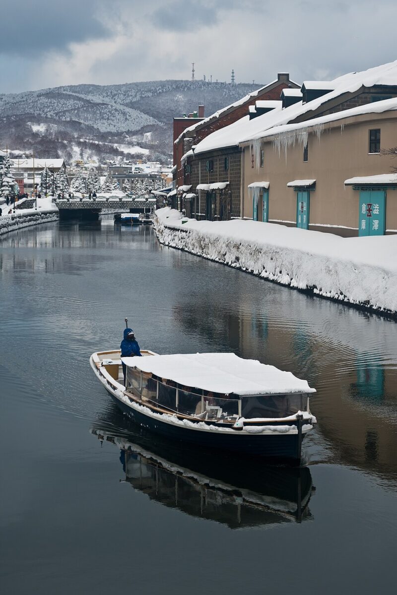 積雪覆蓋石造倉庫時，小樽運河遊船緩慢通過水道